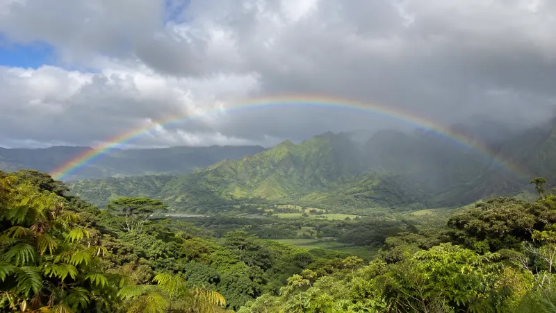 Rainbow over green mountains after a passing shower