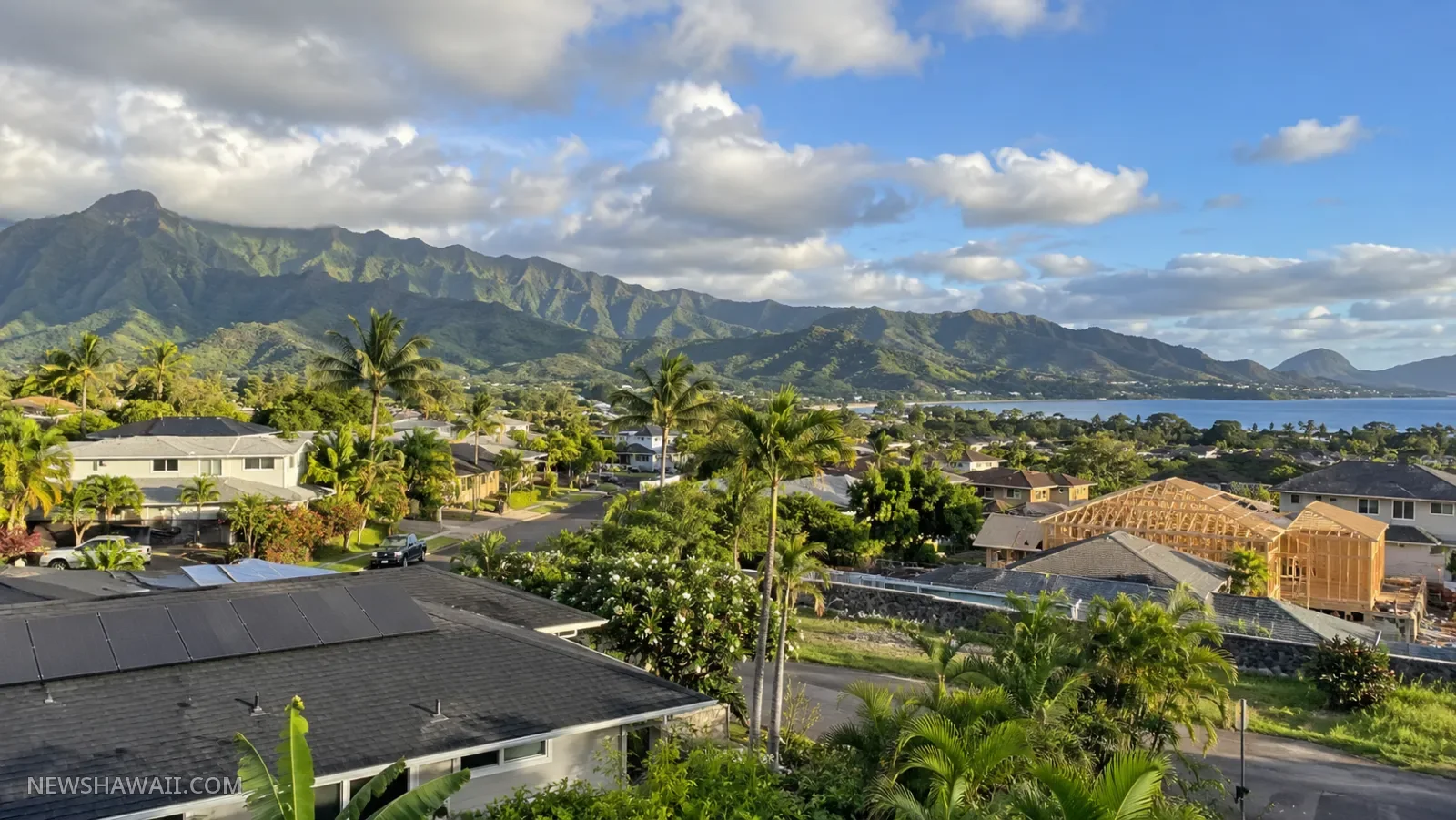 Hawaiʻi neighborhood rooftops and new home construction below green mountains