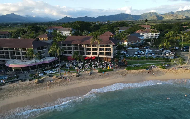 Aerial view of a beachfront resort on Kauaʻi with mountains behind