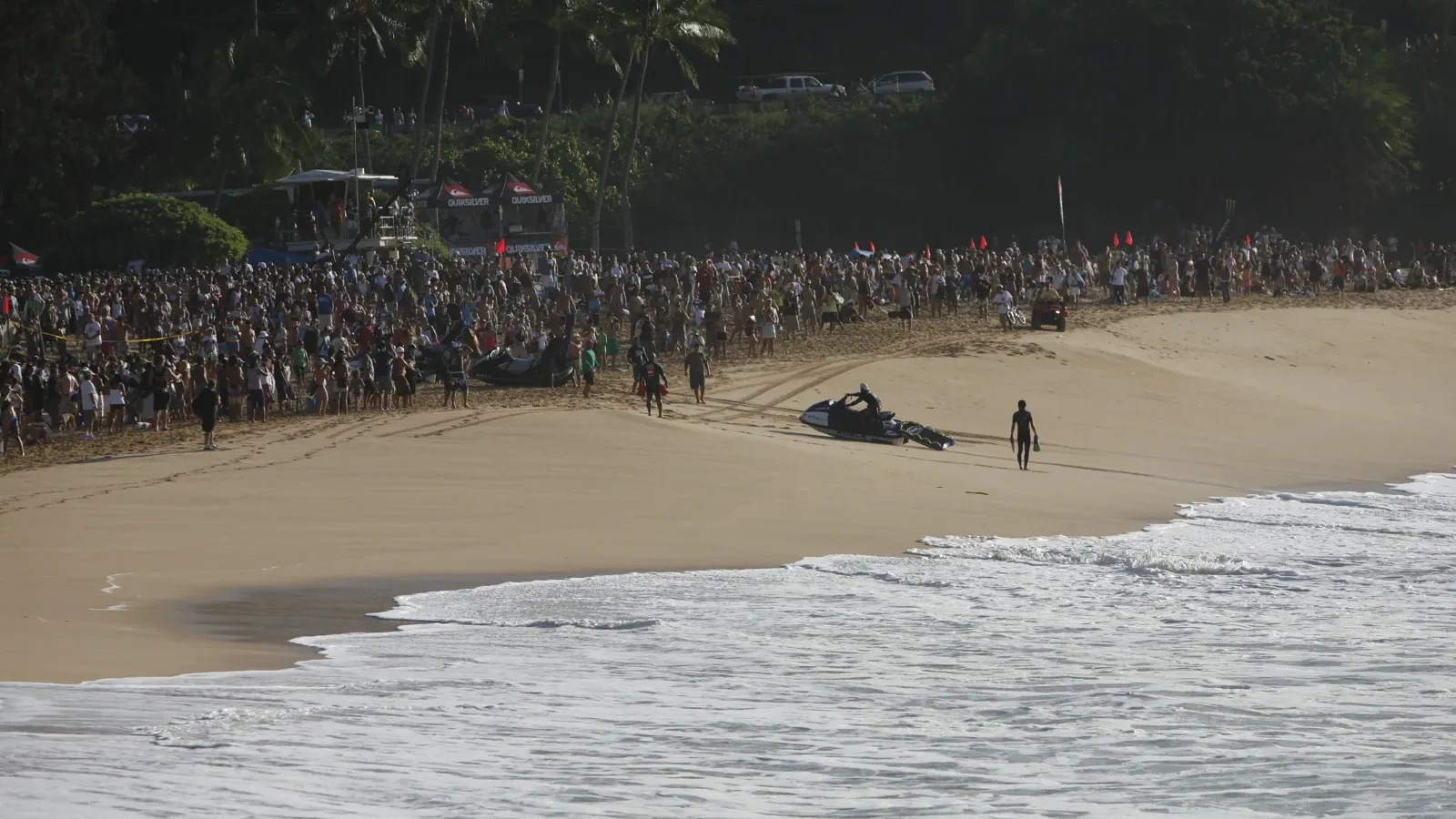 Crowd lining the beach to watch big-wave surfing on Oʻahu’s North Shore