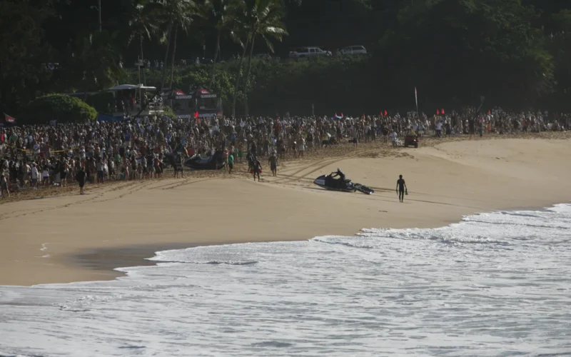 Crowd lining the beach to watch big-wave surfing on Oʻahu’s North Shore