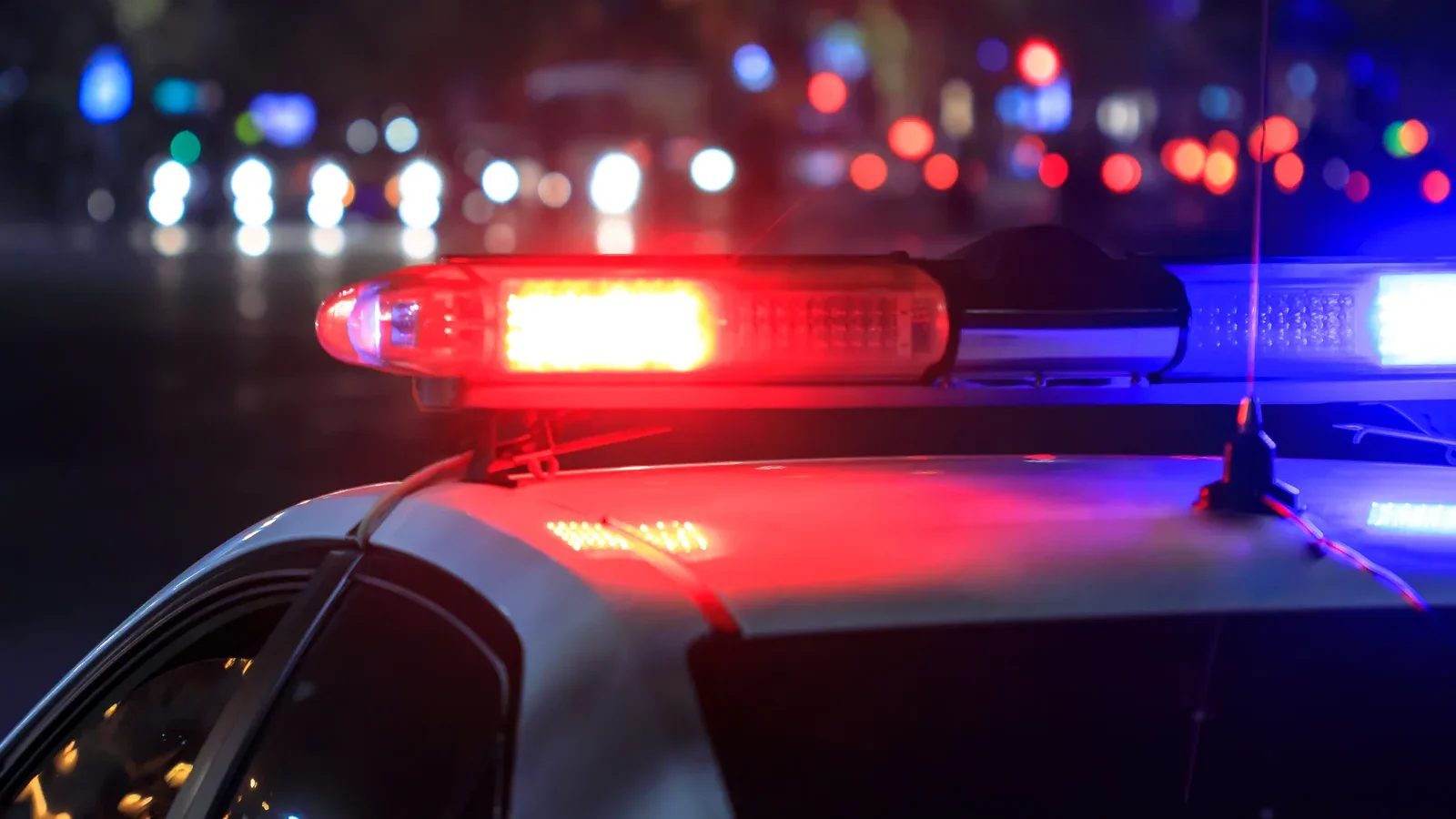 Flashing red and blue lights on top of a police car at night