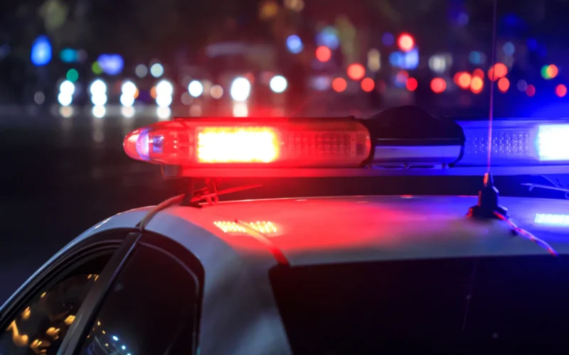 Flashing red and blue lights on top of a police car at night