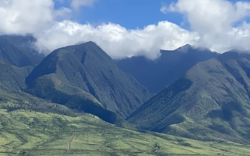 Green slopes of the West Maui Mountains under clouds, seen from the ocean off Lahaina